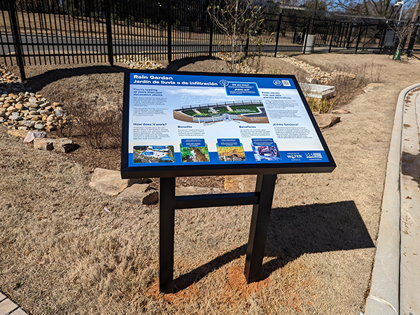 At the One Water Facility, the Rain Garden sign is positioned next to the stormwater control measure.