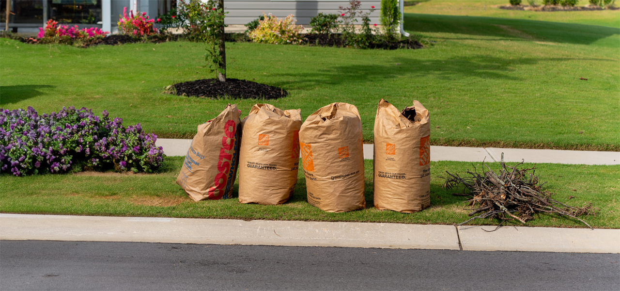 paper bags full of yard waste on curb