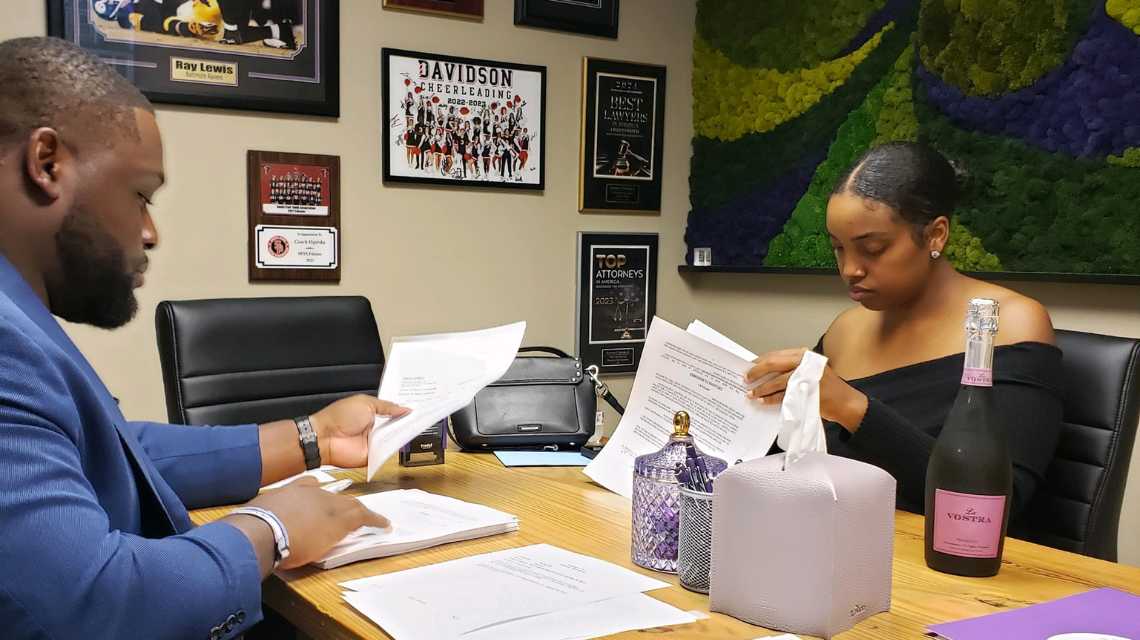 Woman and man sitting together while woman signs document