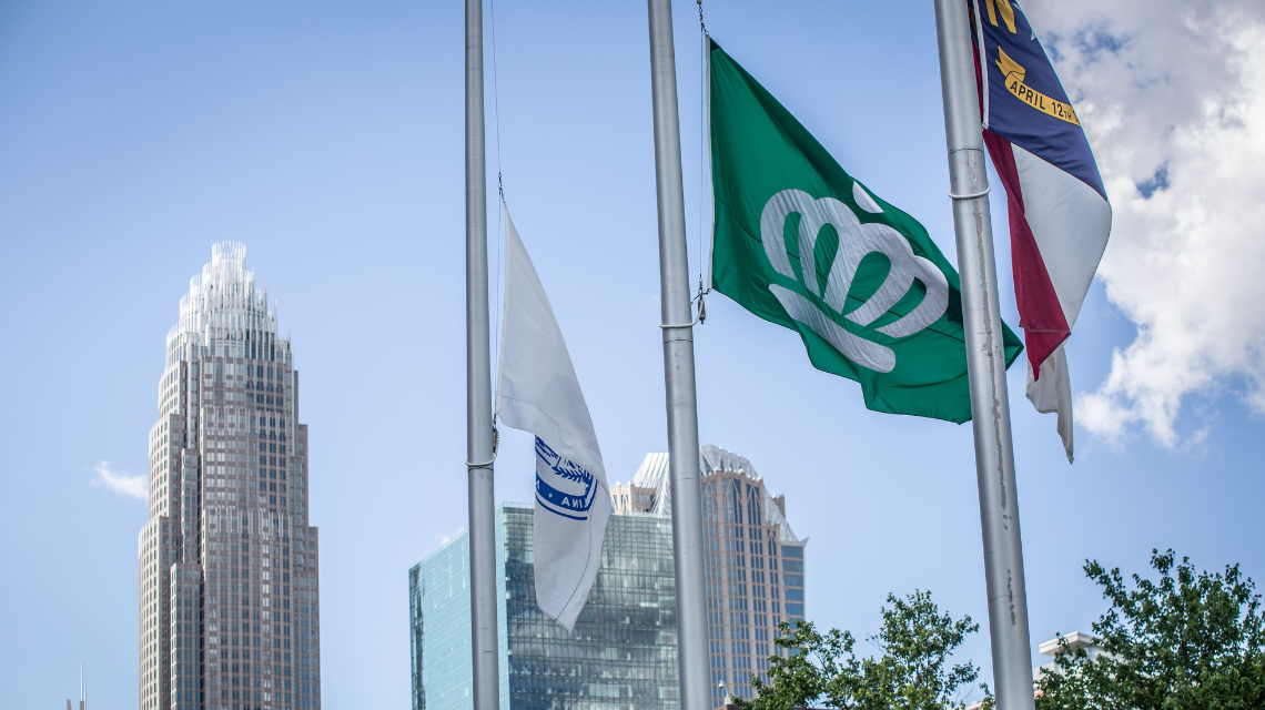 CLT flag in the middle next to american flag and mecklenburg county flag.