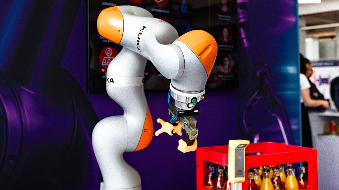 A robot standing perpendicular to the table it is on