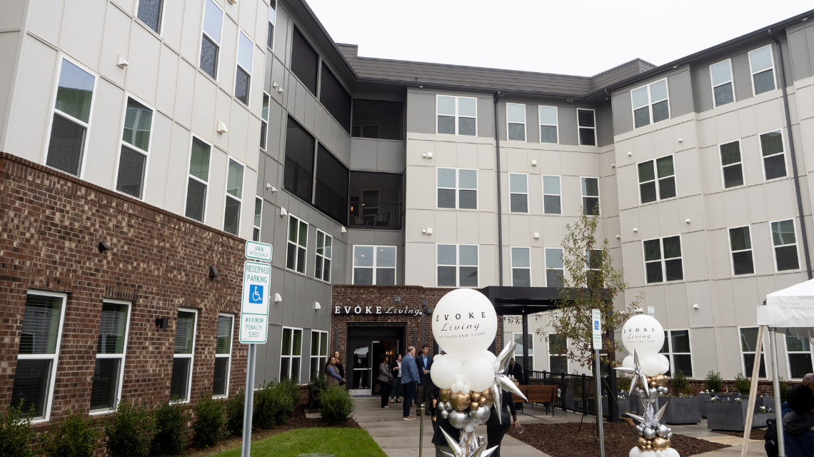 A picture of a new apartment complex with ballons in the front.