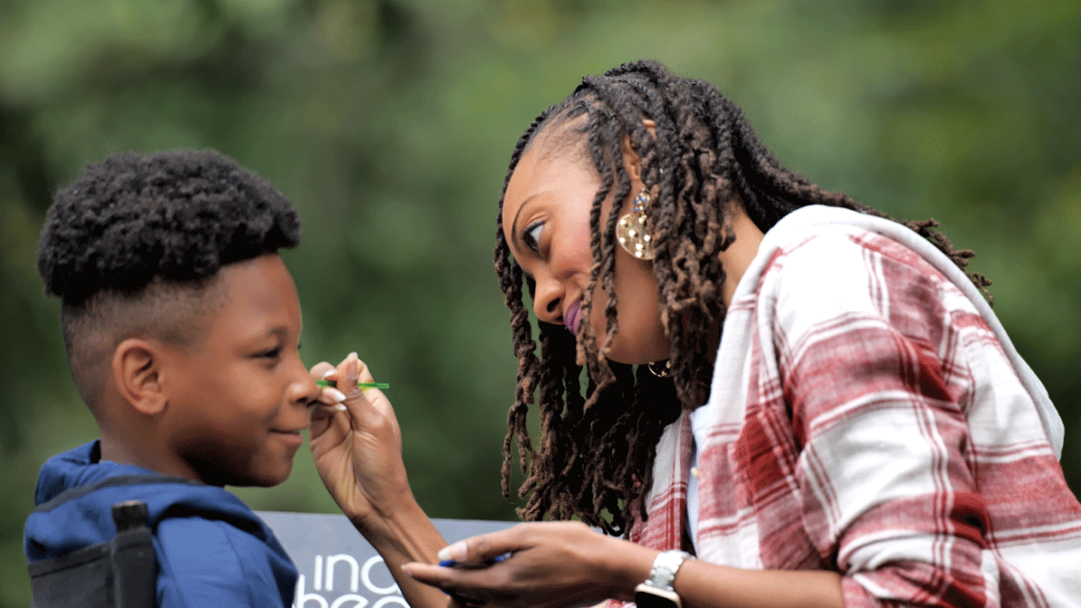 Adult painting a child's face