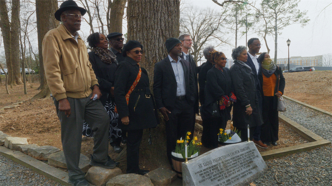 People gathered around St. Lloyd Presbyterian Church Cemetery engraved stone.