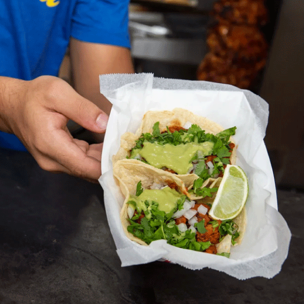 An employee shows off La Caseta’s tacos