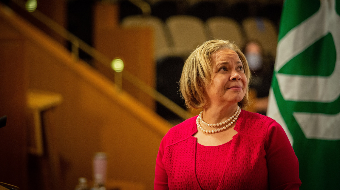 Vi Lyles standing and looking up in council chambers.