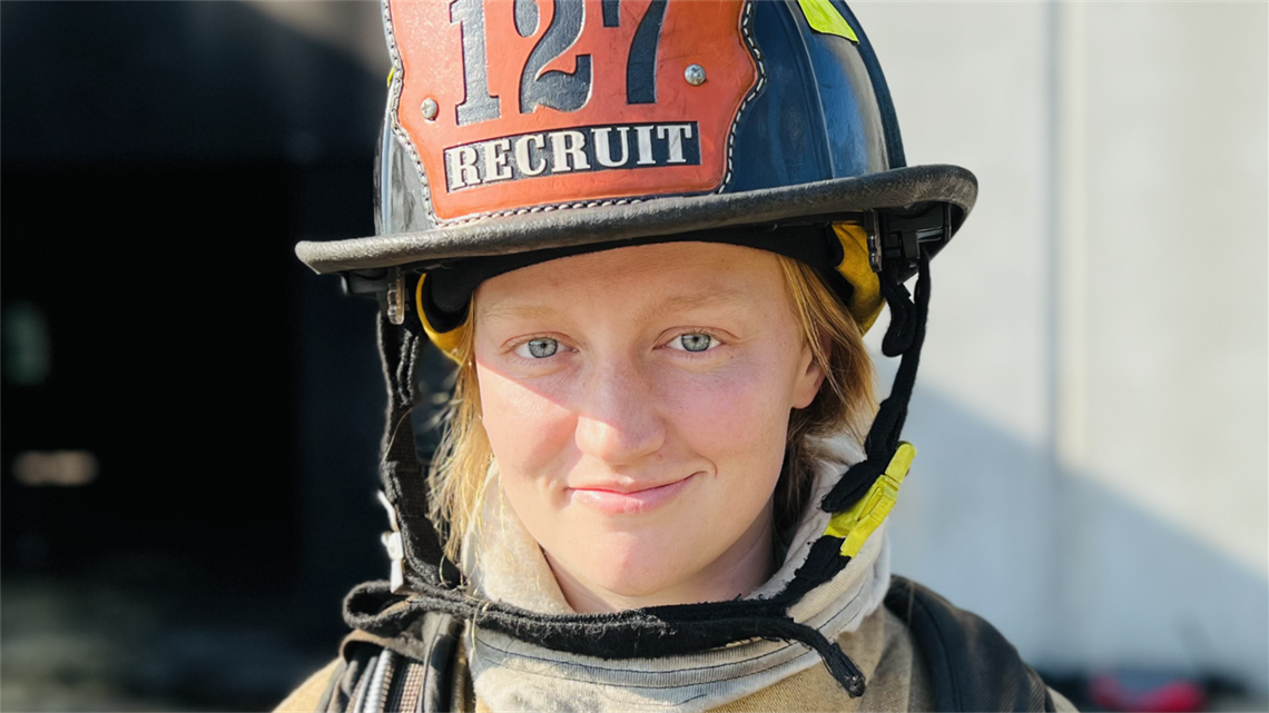 Mallory Gazerro faces the camera and smiles. She's wearing her Recruiting Class 127 helmet.