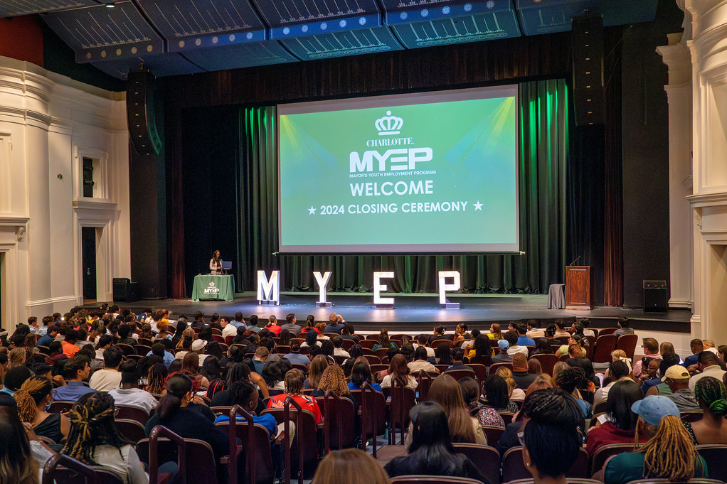 MYEP 2024 Closing Ceremony in CPCC auditorium, featuring a green screen and green curtains.