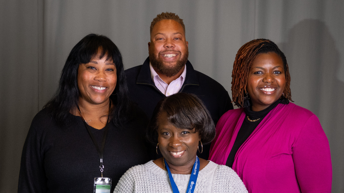 Four workforce development team members posing together for a professional photo.