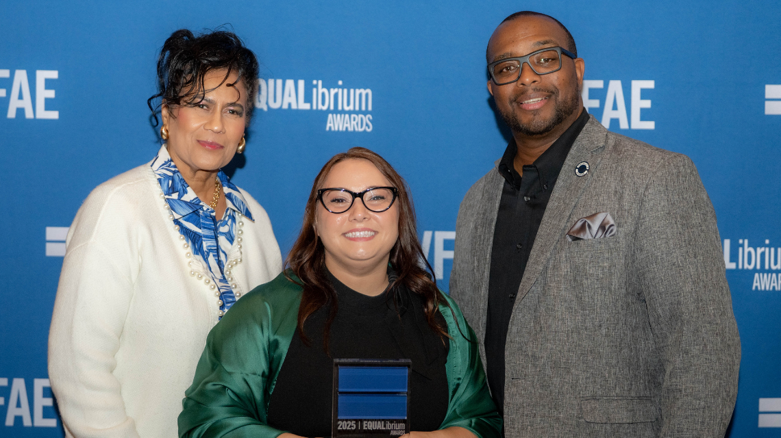 Community Relations members pose in front of banner with their EQUALibrium award.