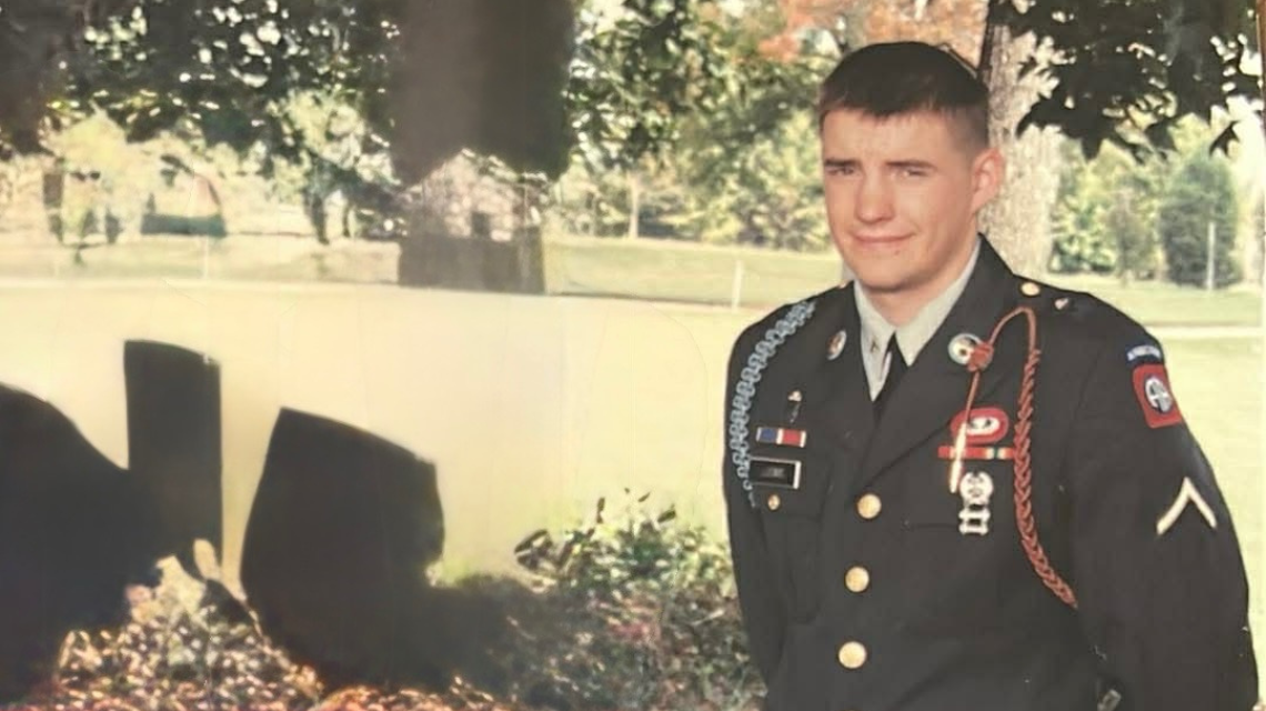 Old photo of Jeffery Ludwig in military uniform standing outside and smiling at the camera.