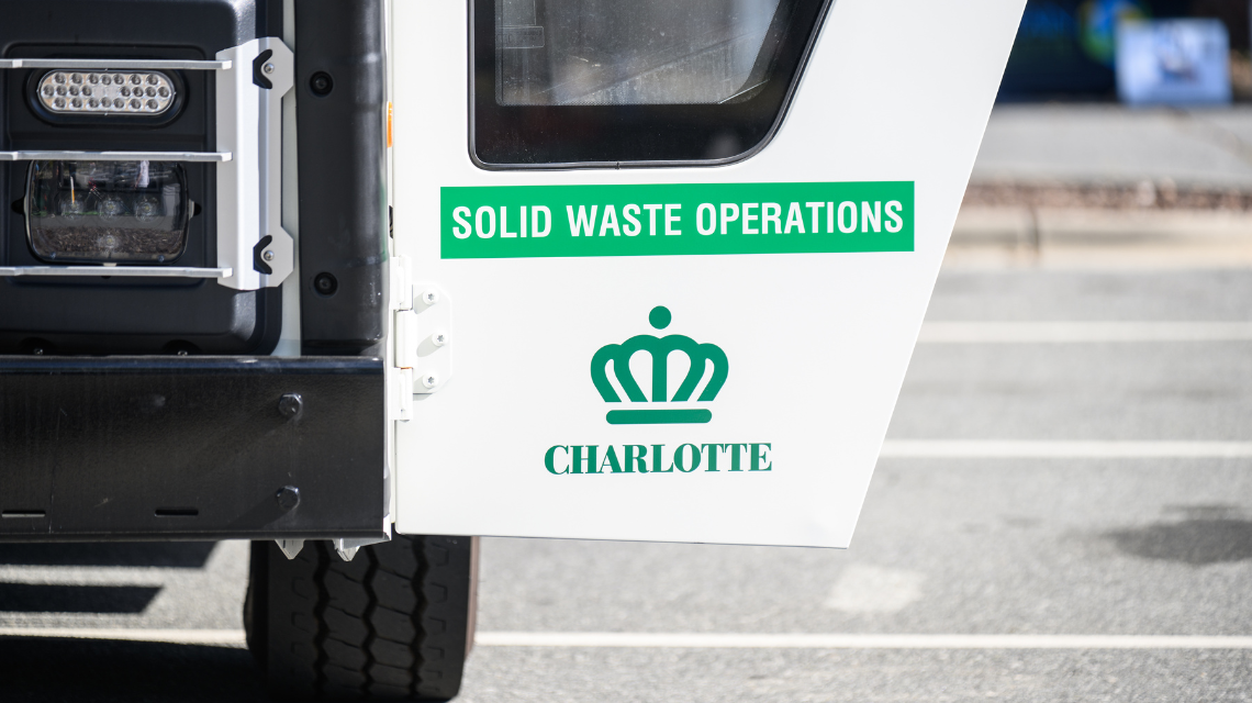 Open door of a solid waste services truck with the city crown logo and text that reads 'solid waste operations.'