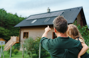 Father and daugher pointing at solar panels on roof of house