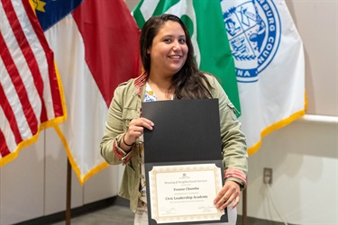 Image of woman holding her certificate from Civic Leadership Academy Session