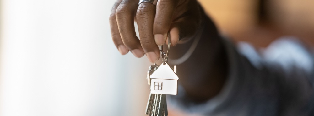 Hand holding keys as if they were giving them to the viewer.