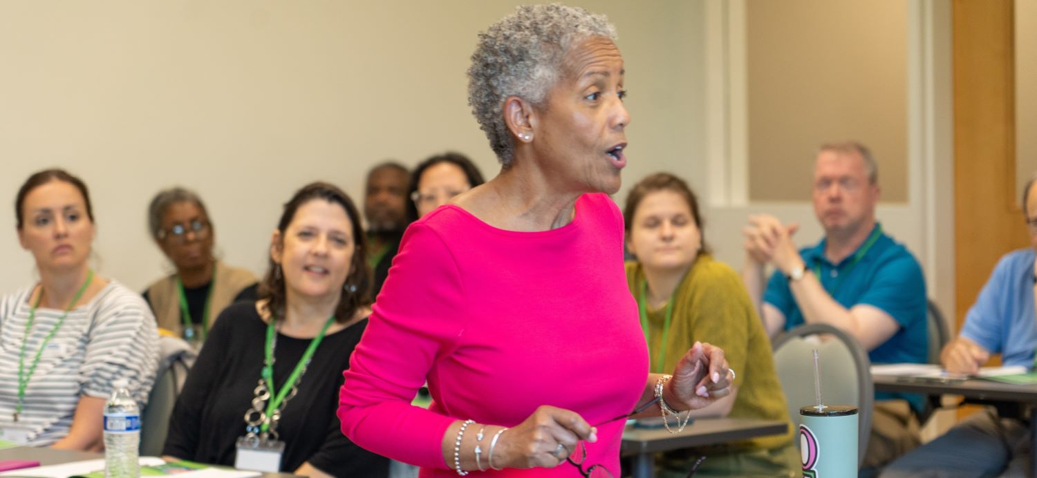 Speaker standing in front of a group of people, speaking.jpg