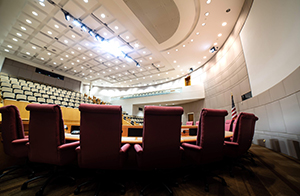 Council members standing behind chairs