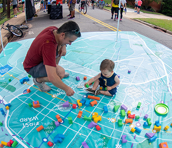 Person Playing with a Child on a map of Charlotte